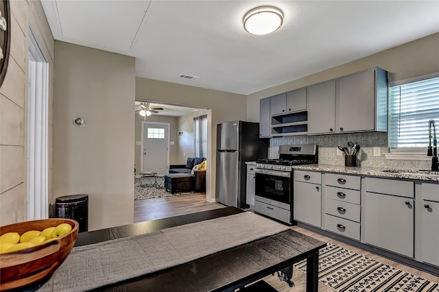 401 W Acheson St, Denison, TX 75020 - kitchen with stainless steel appliances, a sink, gray cabinets, light wood-style floors, and open shelves