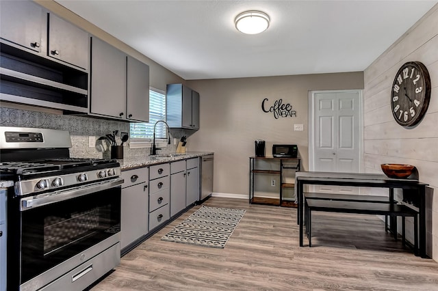 401 W Acheson St, Denison, TX 75020 - kitchen with appliances with stainless steel finishes, a sink, gray cabinets, and light wood-style flooring
