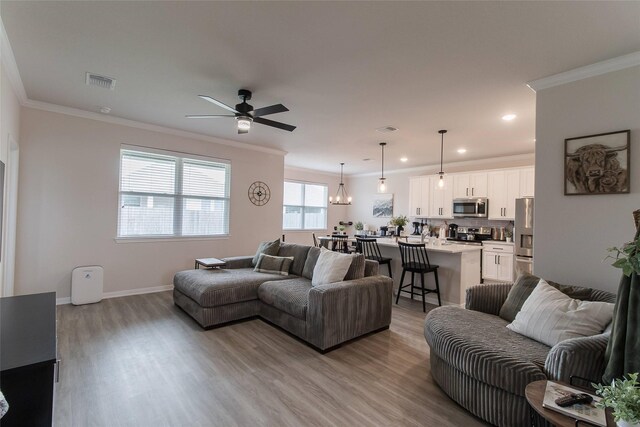 816 Killam Dr, Temple, TX 76502 - living room with wood finished floors, crown molding, ceiling fan, recessed lighting, and baseboards