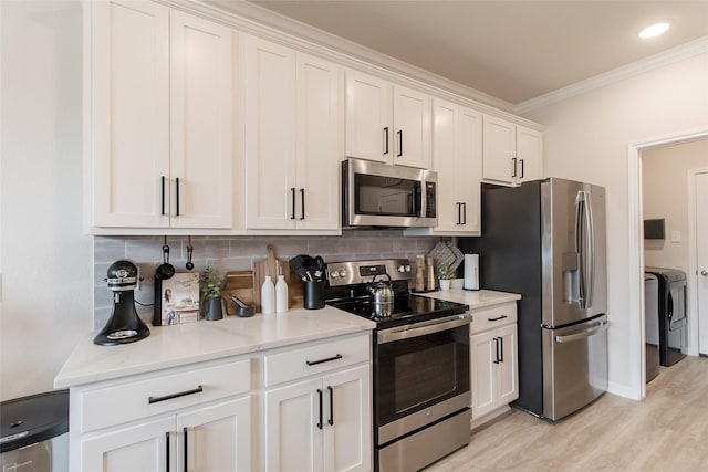 816 Killam Dr, Temple, TX 76502 - kitchen featuring appliances with stainless steel finishes, washing machine and dryer, ornamental molding, decorative backsplash, and white cabinets