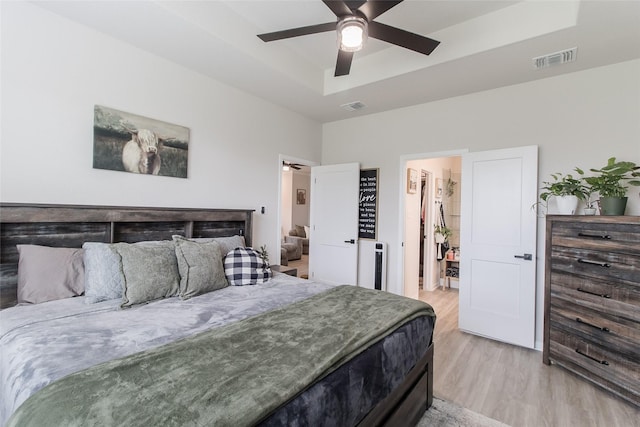 816 Killam Dr, Temple, TX 76502 - bedroom featuring a tray ceiling, light wood-type flooring, a spacious closet, and ceiling fan