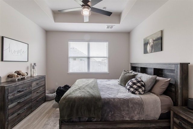 816 Killam Dr, Temple, TX 76502 - bedroom featuring light wood finished floors, a raised ceiling, and a ceiling fan