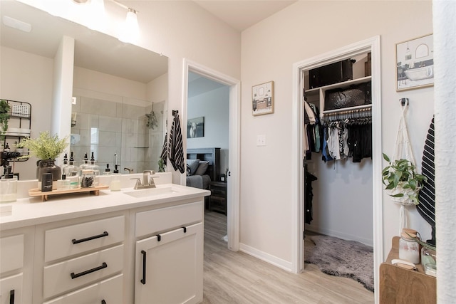 816 Killam Dr, Temple, TX 76502 - full bathroom with a stall shower, wood finished floors, vanity, a walk in closet, and baseboards