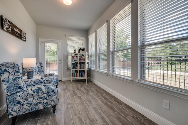 living area with healthy amount of natural light, baseboards, and wood finished floors