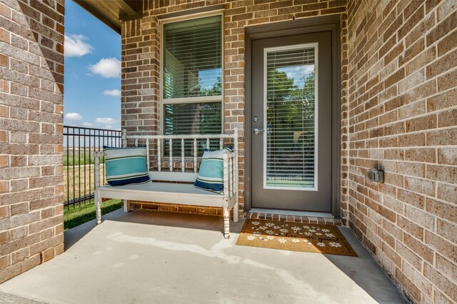 view of exterior entry featuring brick siding