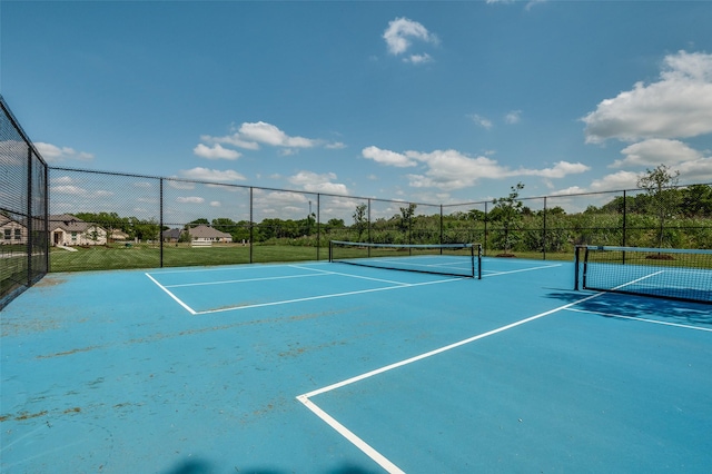 view of tennis court featuring fence