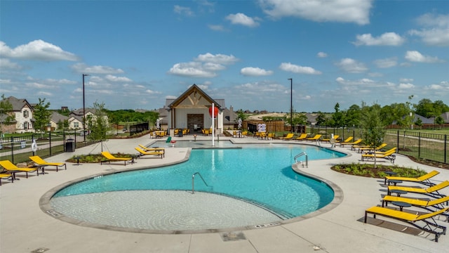 community pool with fence and a patio area