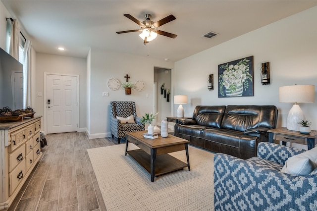 living room with light wood finished floors, a ceiling fan, baseboards, and recessed lighting