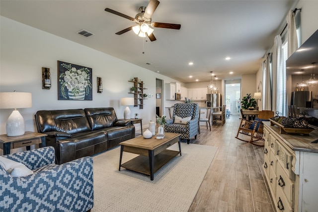 living room featuring ceiling fan, light wood-type flooring, recessed lighting, and healthy amount of natural light