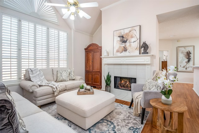 3104 Ridge Hollow Dr, Plano, TX 75023 - living room with ceiling fan, vaulted ceiling, wood finished floors, ornamental molding, and a tile fireplace