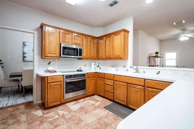 3104 Ridge Hollow Dr, Plano, TX 75023 - kitchen featuring appliances with stainless steel finishes, a sink, backsplash, light countertops, and a textured ceiling