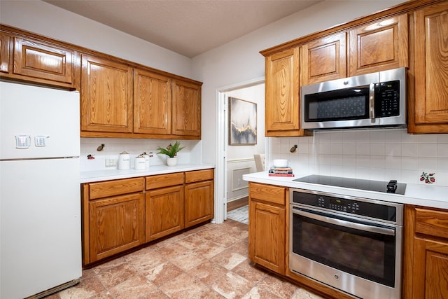 3104 Ridge Hollow Dr, Plano, TX 75023 - kitchen with appliances with stainless steel finishes, brown cabinets, decorative backsplash, light countertops, and stone finish floors