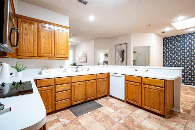 3104 Ridge Hollow Dr, Plano, TX 75023 - kitchen with dishwasher, a peninsula, a sink, brown cabinetry, and recessed lighting