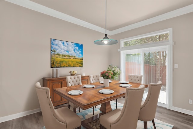 dining space featuring baseboards, light wood-type flooring, and crown molding