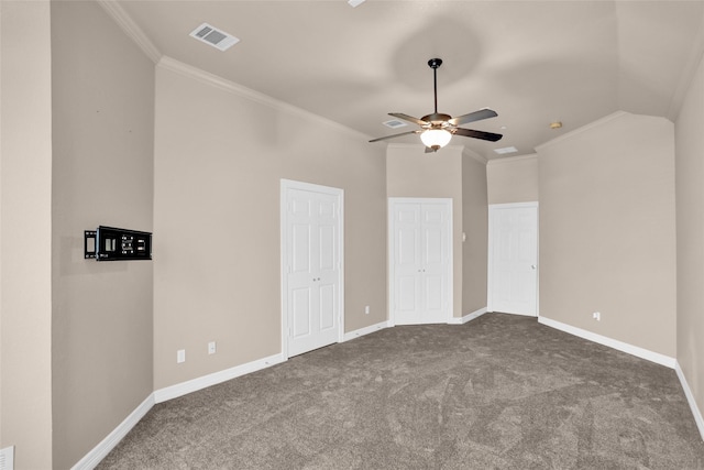 unfurnished bedroom featuring dark carpet, crown molding, baseboards, two closets, and a ceiling fan