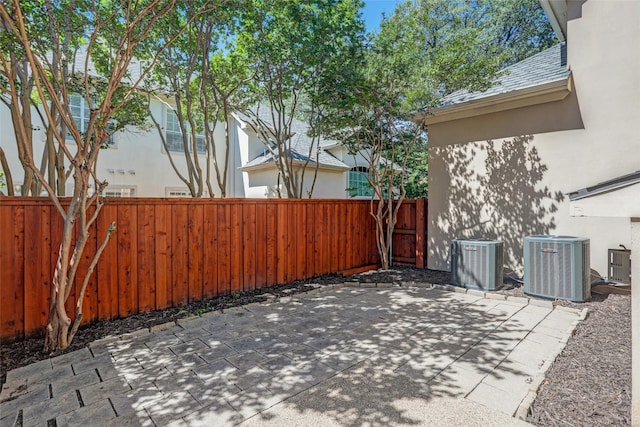 view of patio featuring central AC unit and fence