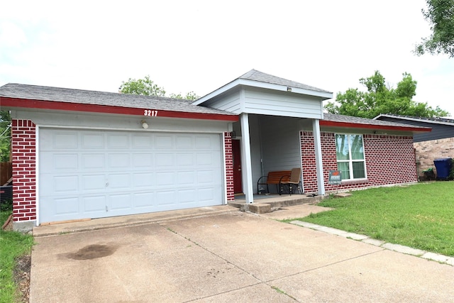 ranch-style home with brick siding, concrete driveway, an attached garage, a front lawn, and roof with shingles