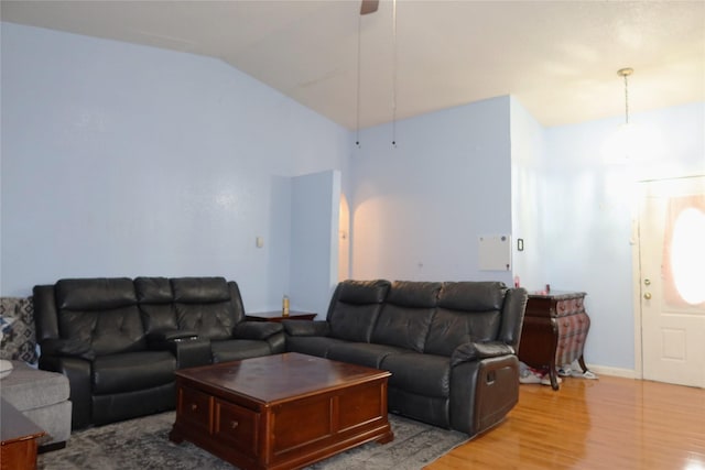 living area featuring wood finished floors, lofted ceiling, ceiling fan, and baseboards