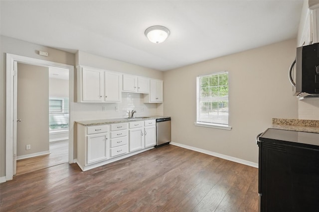 2906 W Parnell St, Denison, TX 75020 - kitchen featuring appliances with stainless steel finishes, a sink, dark wood-style floors, and white cabinets