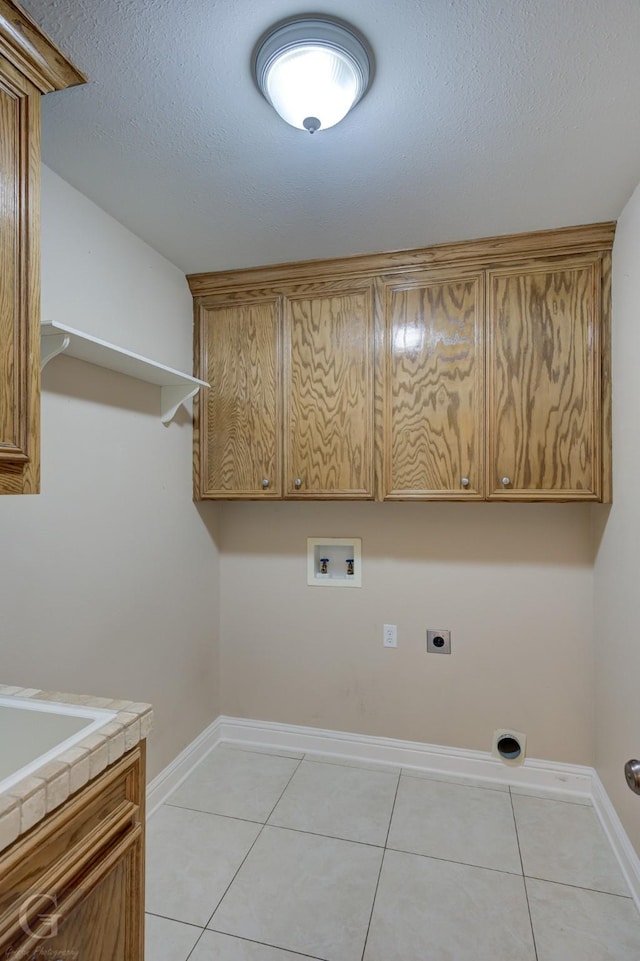 2116 Landau Ln, Bossier City, LA 71111 - clothes washing area featuring electric dryer hookup, cabinet space, hookup for a washing machine, light tile patterned floors, and a textured ceiling
