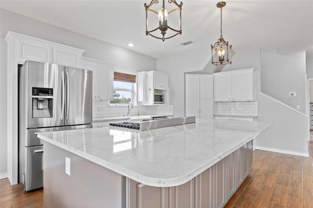 270 Hawk Ln, Brownwood, TX 76801 - kitchen featuring stainless steel appliances, a chandelier, white cabinetry, dark wood-style floors, and decorative backsplash