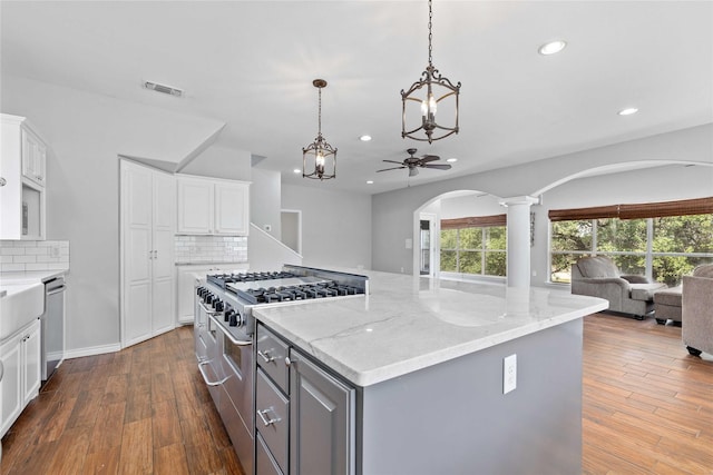 270 Hawk Ln, Brownwood, TX 76801 - kitchen with appliances with stainless steel finishes, arched walkways, open floor plan, gray cabinetry, and a kitchen island