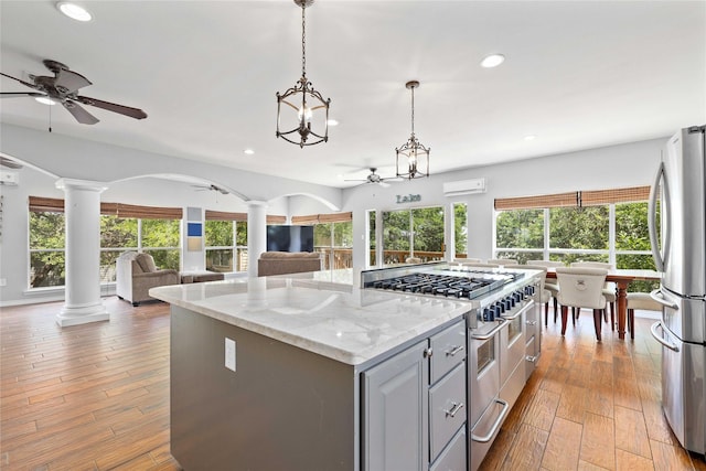 270 Hawk Ln, Brownwood, TX 76801 - kitchen with stainless steel appliances, a ceiling fan, gray cabinetry, decorative columns, and open floor plan