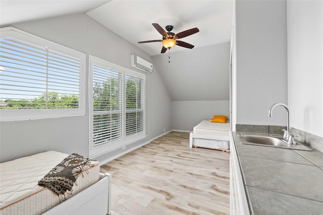 270 Hawk Ln, Brownwood, TX 76801 - bedroom featuring a sink, lofted ceiling, an AC wall unit, light wood-type flooring, and ceiling fan