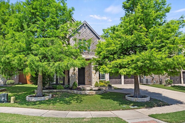 403 Conifer Ln, Allen, TX 75013 - obstructed view of property with concrete driveway, a front lawn, stone siding, and an attached garage