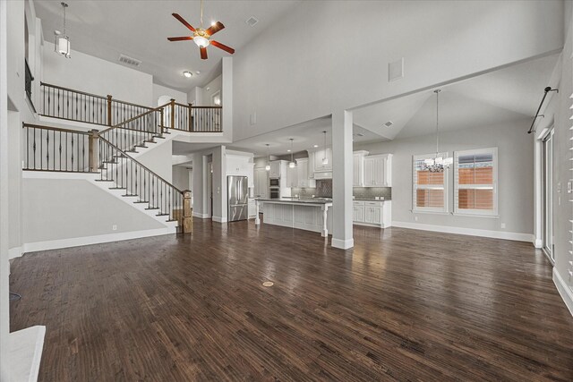 403 Conifer Ln, Allen, TX 75013 - unfurnished living room with ceiling fan, dark wood-style flooring, baseboards, stairway, and high vaulted ceiling