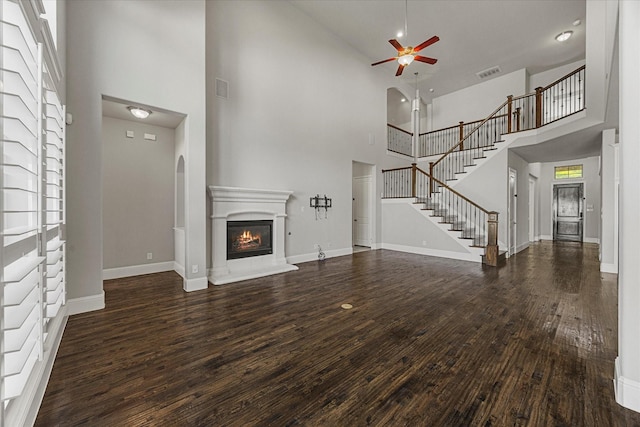 403 Conifer Ln, Allen, TX 75013 - unfurnished living room with a towering ceiling, ceiling fan, wood finished floors, a glass covered fireplace, and baseboards
