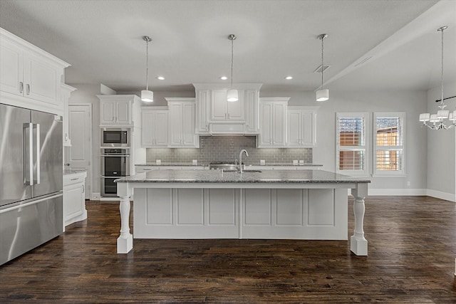 403 Conifer Ln, Allen, TX 75013 - kitchen featuring appliances with stainless steel finishes, tasteful backsplash, dark wood-style floors, a kitchen breakfast bar, and recessed lighting