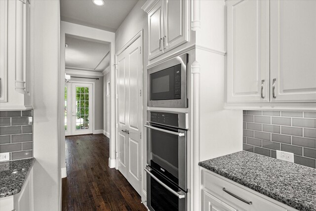 403 Conifer Ln, Allen, TX 75013 - kitchen with built in microwave, white cabinetry, dark stone counters, dark wood finished floors, and backsplash