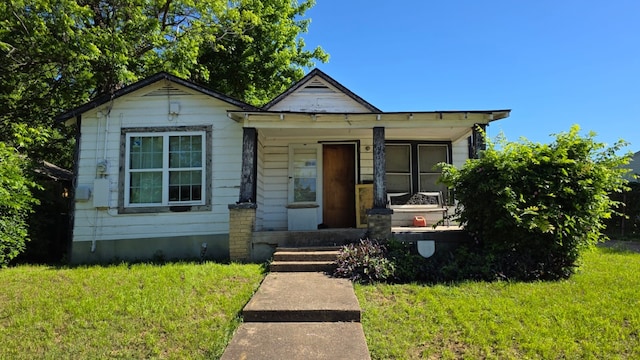 bungalow-style home with a porch and a front lawn