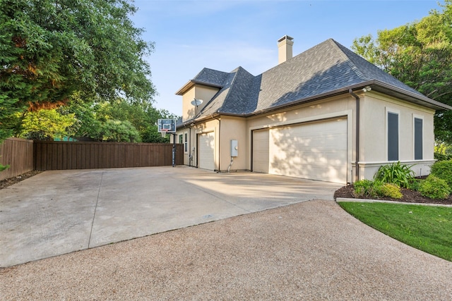 1104 Windsor Dr, Mckinney, TX 75072 - view of side of home with fence, concrete driveway, stucco siding, an attached garage, and a chimney