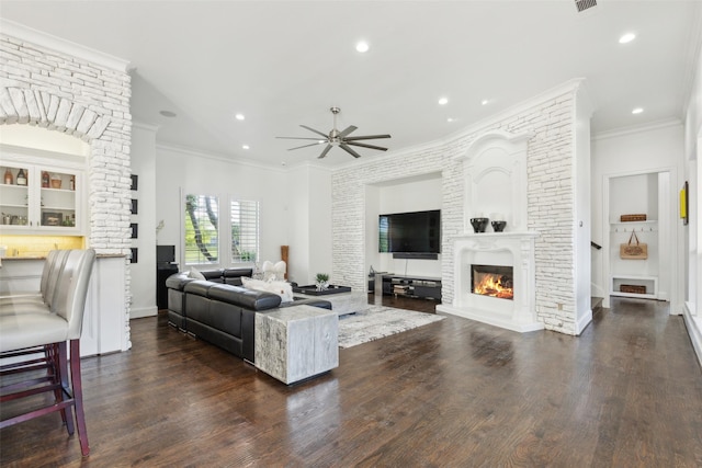 1104 Windsor Dr, Mckinney, TX 75072 - living area featuring a glass covered fireplace, a ceiling fan, dark wood-type flooring, recessed lighting, and ornamental molding