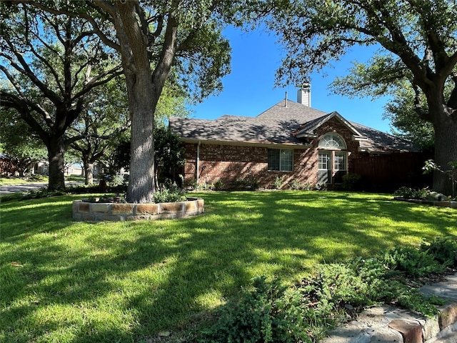5900 Sandhill Cir, The Colony, TX 75056 - view of front of house with a front yard, a chimney, and brick siding