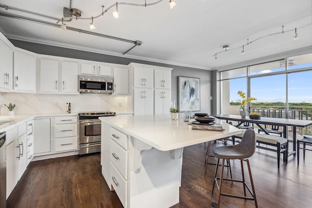 6211 W NW Unit 701, Dallas, TX 75225 - kitchen with stainless steel appliances, crown molding, a kitchen island, a wall of windows, and dark wood-style flooring
