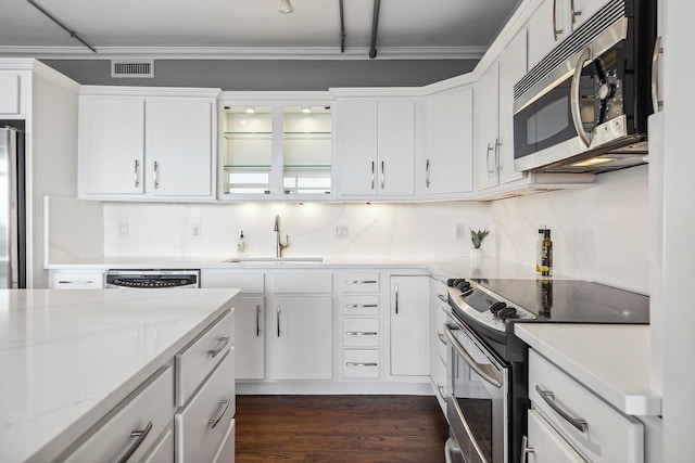 6211 W NW Unit 701, Dallas, TX 75225 - kitchen featuring appliances with stainless steel finishes, a sink, dark wood-style flooring, white cabinetry, and crown molding