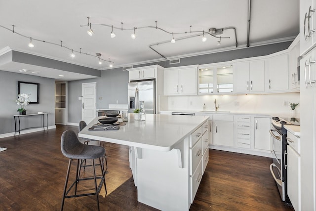 6211 W NW Unit 701, Dallas, TX 75225 - kitchen with stainless steel appliances, a kitchen island, light countertops, white cabinets, and crown molding