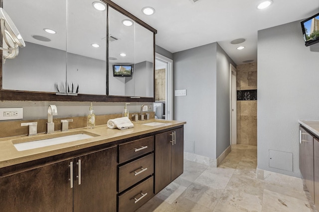 6211 W NW Unit 701, Dallas, TX 75225 - bathroom with double vanity, baseboards, tiled shower, and recessed lighting