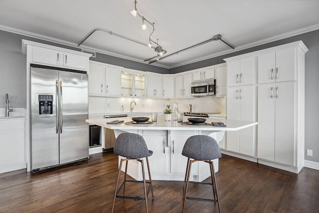 6211 W NW Unit 701, Dallas, TX 75225 - kitchen featuring stainless steel appliances, dark wood-style flooring, light countertops, white cabinets, and ornamental molding