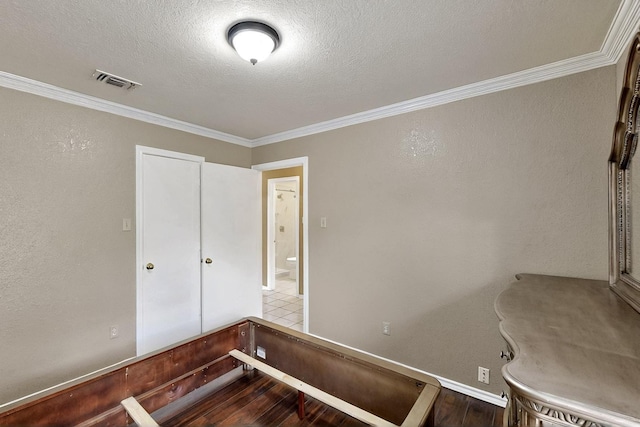 208 Lydia Cir, Irving, TX 75060 - unfurnished bedroom with crown molding, wood finished floors, and a textured ceiling