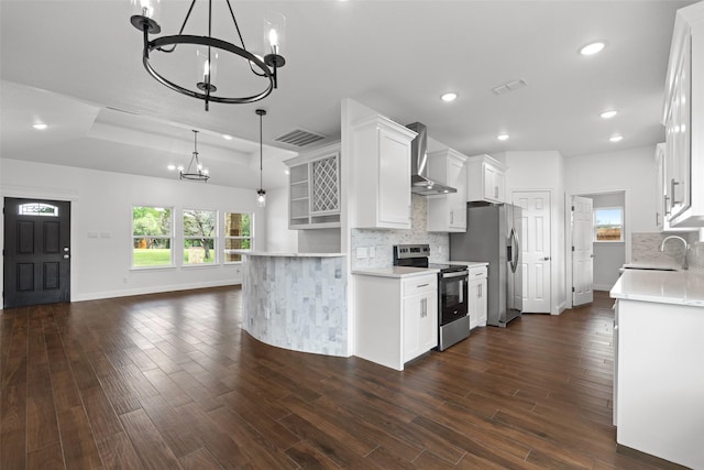 kitchen with appliances with stainless steel finishes, wall chimney exhaust hood, a chandelier, a sink, and recessed lighting
