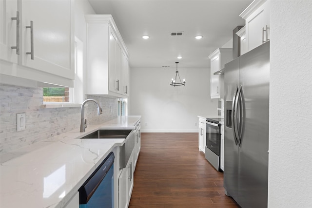 kitchen featuring appliances with stainless steel finishes, backsplash, white cabinetry, dark wood-style floors, and light stone counters