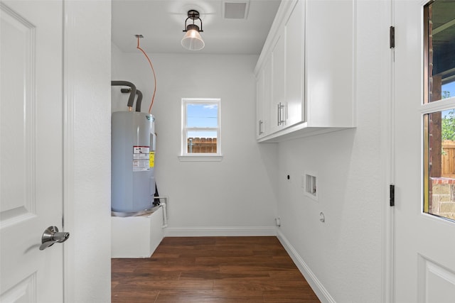 laundry area with cabinet space, electric water heater, dark wood-type flooring, hookup for an electric dryer, and plenty of natural light