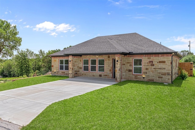 rear view of property with a shingled roof, stone siding, and driveway