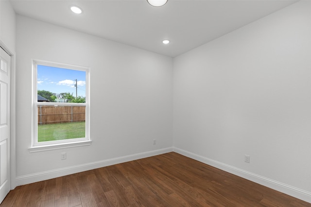 spare room with dark wood-type flooring, baseboards, and recessed lighting