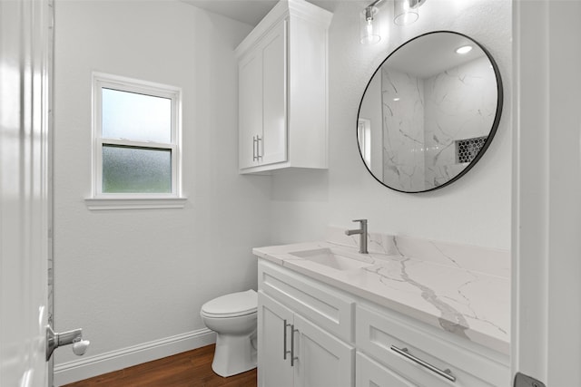 bathroom featuring vanity, wood finished floors, toilet, and baseboards