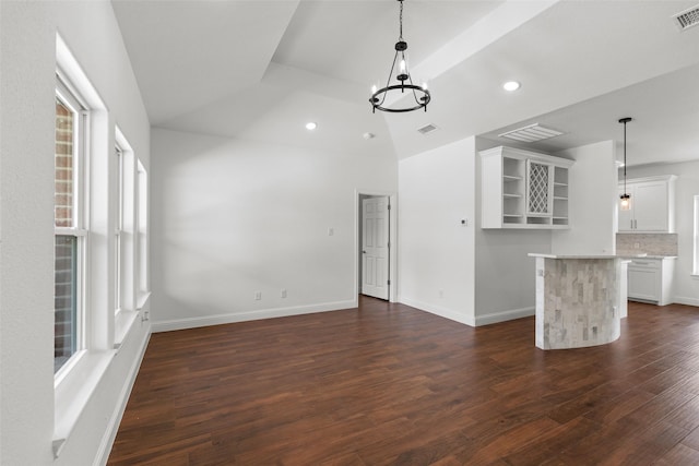 unfurnished living room featuring dark wood finished floors, lofted ceiling, a chandelier, recessed lighting, and baseboards